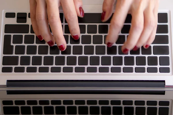 Genç bir kadın dizlerinin üstünde dizlerinin üstünde yatak odasındaki yatakta çalışıyor. Evde çalışıyorum..