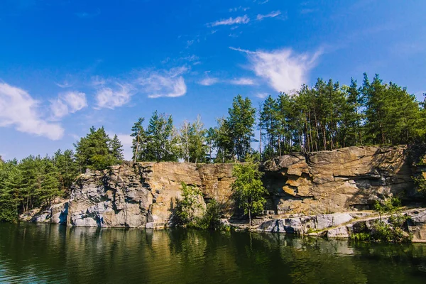 Korostyshiv Canyon, Zhytomir bölgede yeşil su ile derin göl ve Ukrayna ve köknar ormandaki mavi gökyüzü