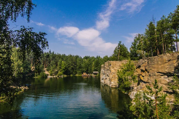 Korostyshiv Canyon, Zhytomir bölgede yeşil su ile derin göl ve Ukrayna ve köknar ormandaki mavi gökyüzü