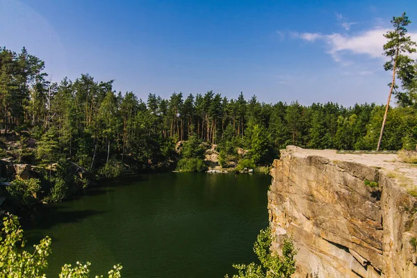 Korostyshiv Canyon, Zhytomir bölgede yeşil su ile derin göl ve Ukrayna ve köknar ormandaki mavi gökyüzü