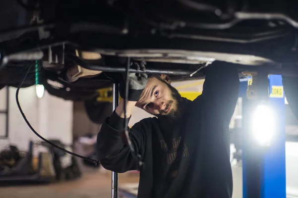 プロ仕様のツールが付いている車を修理の若い白人男 — ストック写真