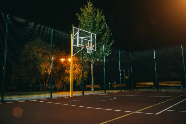 Işıklı basketbol Bahçesi Kırmızı kaldırım, modern yeni basketbol net ve arka plan üzerinde objektif mercek parlamaları. 