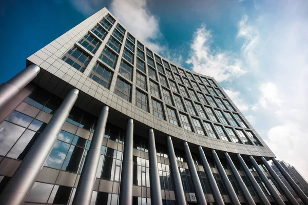 Close up of administrative building - buseiness center of NSC Olimpyiskiy stadium in Kyiv, Ukraine with deep blue sky on background and different constructions