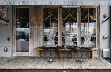 Bir kafe cephe tasarımı şık elemanları ve mobilya ile. Ahşap elemanları çok.