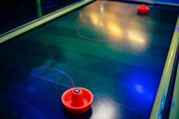 Colorful air hockey on dark interior and blue backgrounds