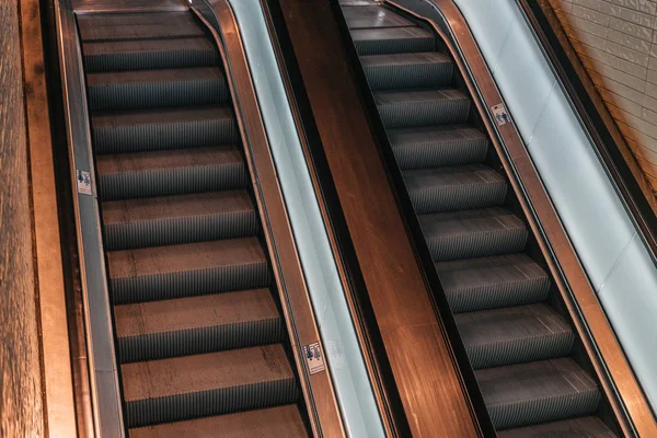 Dark public escalator with warm light — Stock Photo, Image