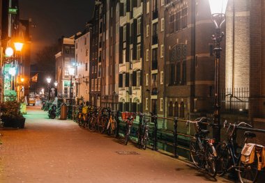 Bisiklet park ve sıcak ışık ile gece rahat Amsterdam sokakları