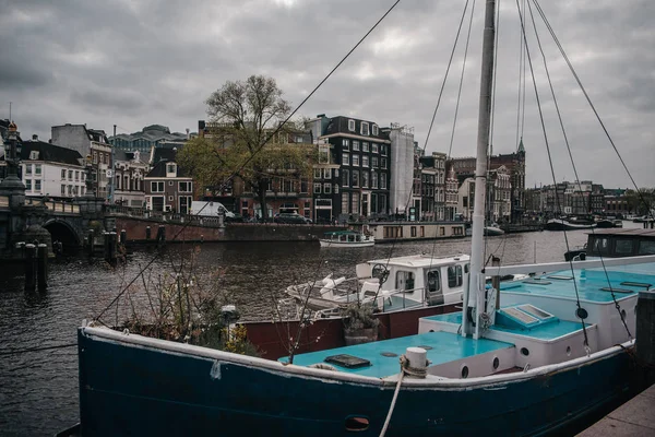 Amsterdamm steg mit parkendem schiff auf europäischen häusern hintergrund — Stockfoto