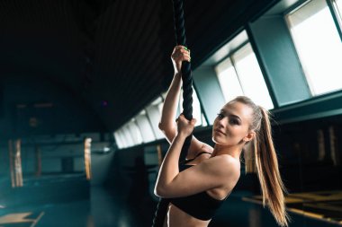 Tırmanma ipi ile bir kadının tam uzunlukta dar açı atış. Co