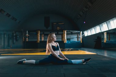 Germe jimnastikçi kız dikey split yapıyor, ip. Yan görünüm o