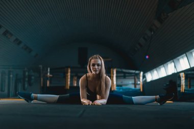 Germe jimnastikçi kız dikey split yapıyor, ip. Yan görünüm o