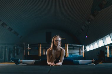 Germe jimnastikçi kız dikey split yapıyor, ip. Yan görünüm o