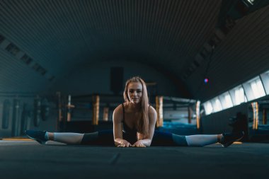 Germe jimnastikçi kız dikey split yapıyor, ip. Yan görünüm o