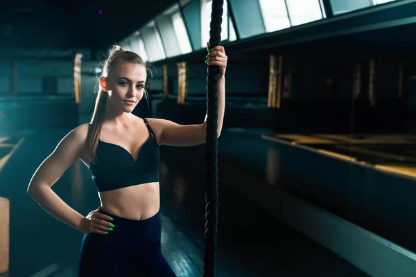 Full length narrow angle shot of a woman with climbing rope.  Co