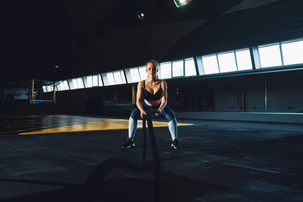 Full length wide angle shot of a young woman working out with ba