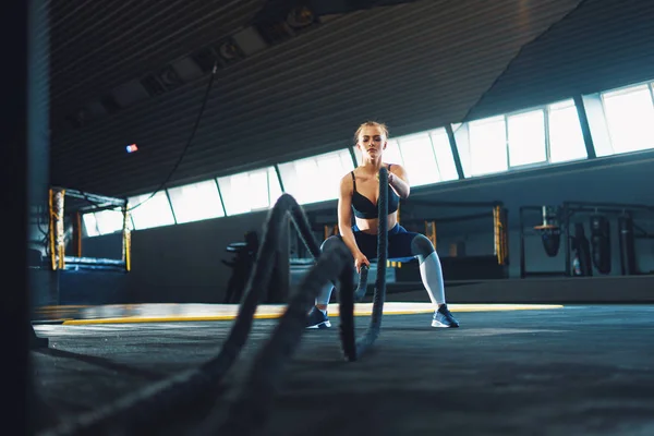 Full length wide angle shot of a young woman working out with ba