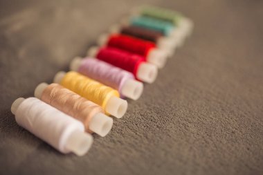 Çok renkli dikiş iplikleri, tekstil, kumaş ve el işçiliği konseptinin makro çekimi.