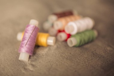 Çok renkli dikiş iplikleri, tekstil, kumaş ve el işçiliği konseptinin makro çekimi.