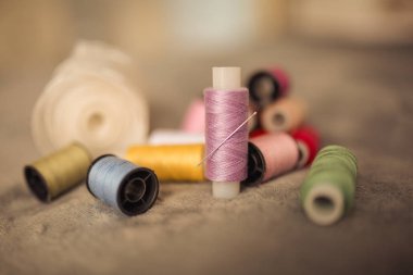 Çok renkli dikiş iplikleri, tekstil, kumaş ve el işçiliği konseptinin makro çekimi.