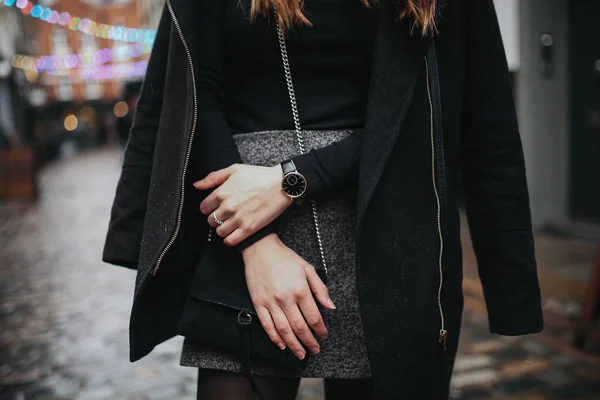 雨の中で黒いトップ 黒いコートと灰色のスカートを着て 雨の下で若いファッショナブルな女性 ストリートスタイル ブログ ライフスタイルのコンセプト 衣装の詳細に選択的な焦点を当てた水平画像 — ストック写真
