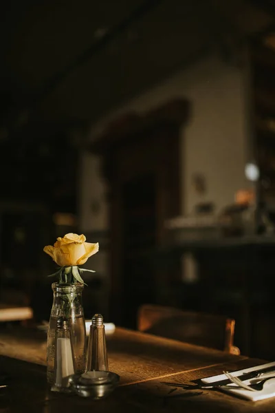 Cam eşyalar ve bir çiçekle hazırlanan romantik bir akşam yemeğinin yakın çekim çekimi. Restoran iş kavramı, catering ve misafirperverliği. Metniniz için ücretsiz kopyalama alanı olan dikey görüntü. 