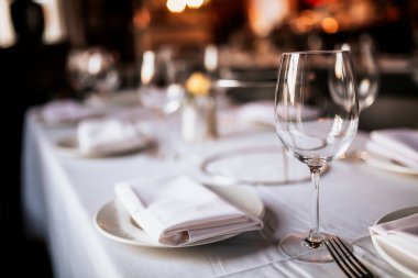 Bir restoran masa masa masa nın yakın çekim masa ve şarap kadehi ile kurmak. Yemek, misafirperverlik ve catering kavramı. Metin için boş alan içeren yatay görüntü. 