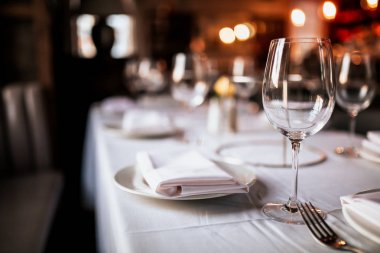 Bir restoran masa masa masa nın yakın çekim masa ve şarap kadehi ile kurmak. Yemek, misafirperverlik ve catering kavramı. Metin için boş alan içeren yatay görüntü. 