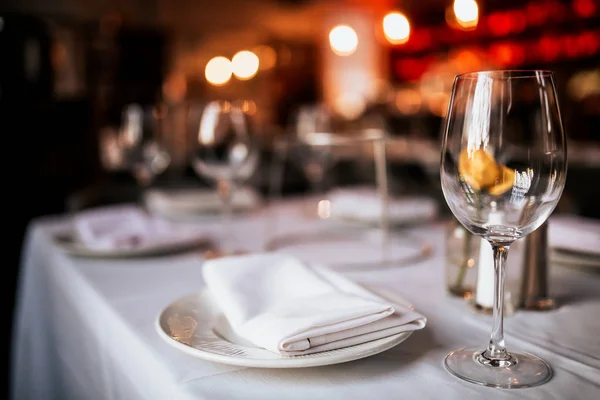 Bir restoran masa masa masa nın yakın çekim masa ve şarap kadehi ile kurmak. Yemek, misafirperverlik ve catering kavramı. Metin için boş alan içeren yatay görüntü. 