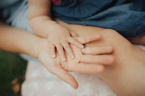 Bebeğinin elini tutan bir anne fotoğrafı. Sevgi, annelik, ebeveynlik ve aile kavramı. 