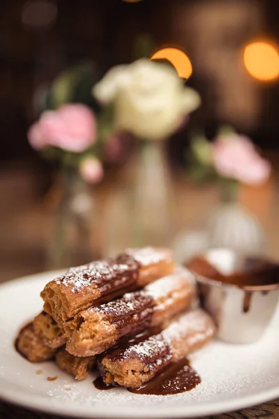 Tarçın şeker çikolata sosu ile churros tozlu. Gıda, tatlı ve pişirme kavramı. Geleneksel Meksika yemekleri.