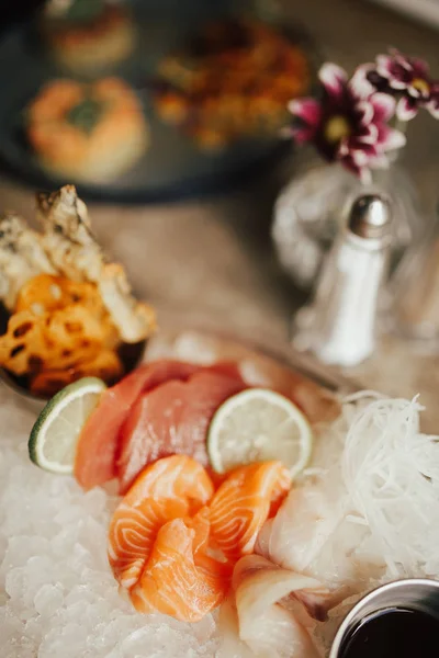 Ton balığı ve somon sashimi tabağı bir yakın çekim makro çekim. Japon mutfağı kavramı, misafirperverliği ve diyet. Taze çiğ balık Japon incelik ince parçalar halinde dilimlenmiş, soya sosu ile servis.