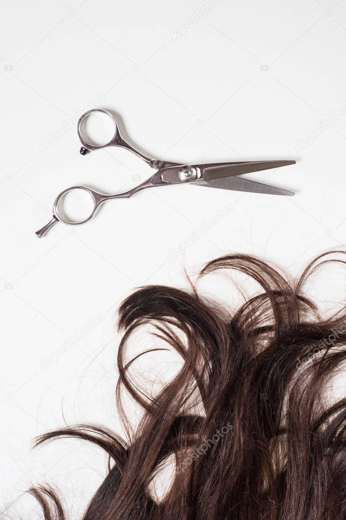 brunette long hair with scissors isolated on white background