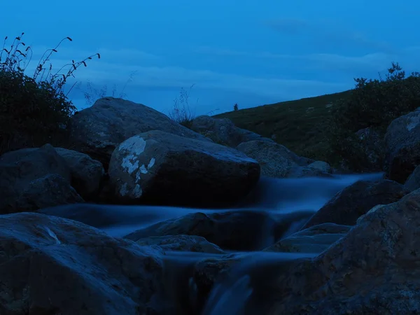 dusk view of splashing clean water of mountain stream with big stones, Altai Mountains, Russia