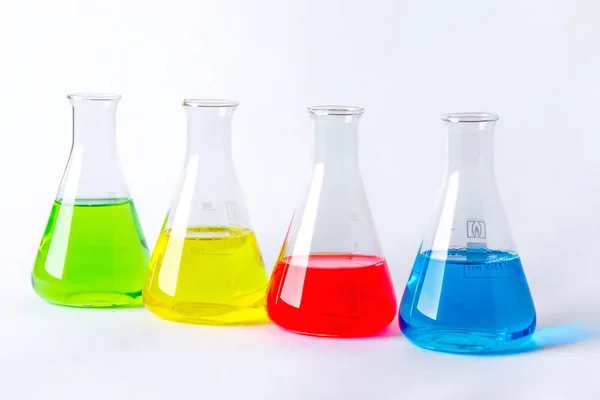 Quatre Flacons Laboratoire Avec Des Liquides Colorés Isolés Sur Blanc — Photo