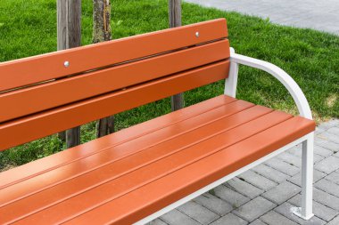 Taze turuncu park bankında boyalı. Şehir ve kamu parki altyapı. Açık ayrıntıları.