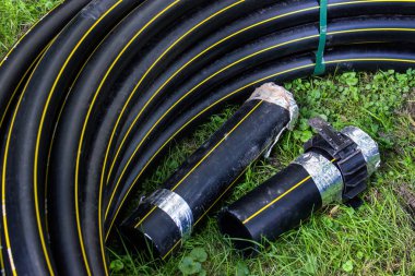 Siyah borulara işleri onarmak için hazır çim döşeme.