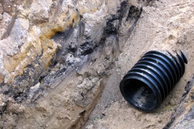 Toprak altında siyah plastik boru. Su sistemi, altyapı. Onarım işleri.