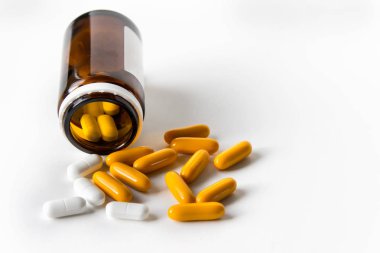 Metin için boş alan ile beyaz arka plan üzerinde beyaz ve sarı hap kahverengi cam şişe.