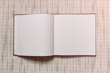 Büyük kare boş beyaz çarşaflı dokulu kumaş arka plan üzerinde döşeme dizüstü açtı.