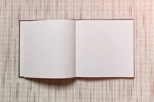 大きな広場質感のファブリックの背景を置くこと空白の白いシーツでノートブックを開く — ストック写真