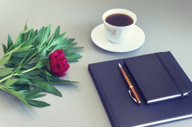 Siyah defterler, kahve fincan ı ve bir kalem ile şakayık çiçek