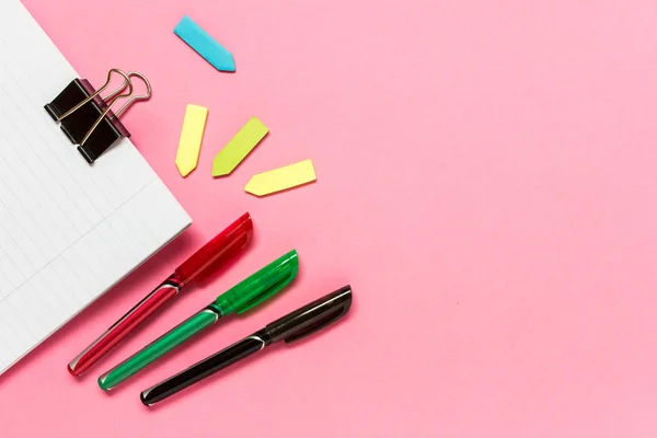 Renkli kalemler, yapışkan notlar, pembe arka plan üzerine not defteri — Stok fotoğraf