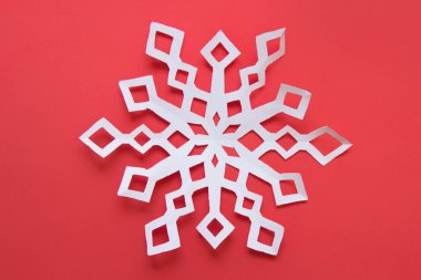 Kırmızı arka planda büyük beyaz kar taneleri