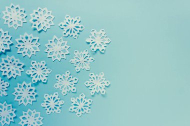 Mavi arka planda kağıt kar taneleri