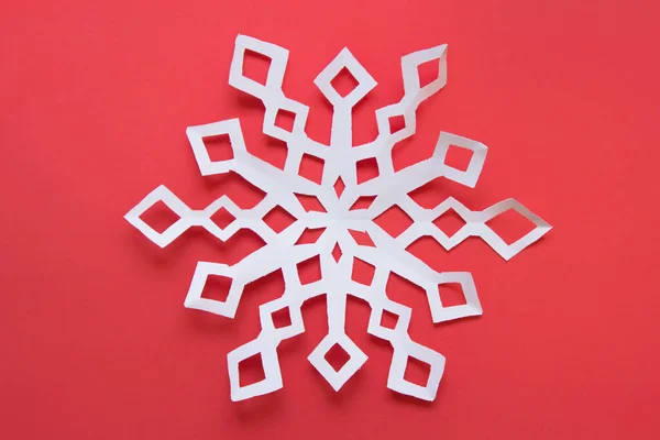 Large white paper snowflake on red backgound — Stock Photo, Image