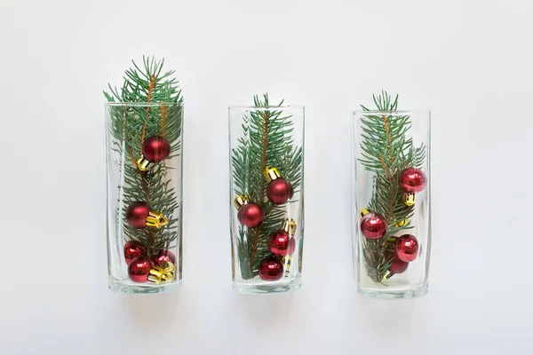 Tres vasos con ramas de abeto siempreverde y bolas rojas — Foto de Stock