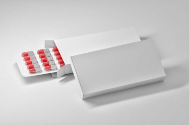 İki beyaz tıbbi ambalaj kutusu ve plastik su toplamada kırmızı beyaz hap kapsülleri ile çapraz düzenleme şablonu. 3d illüstrasyon.
