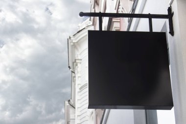 Arkaplanda mavi gökyüzü olan ön cephe üzerine kare siyah dükkan tabelasıyla kırtasiye şablonu