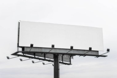 Büyük mega pano, içi boş boş reklam panosu ve gri gökyüzü arka planında ışık.