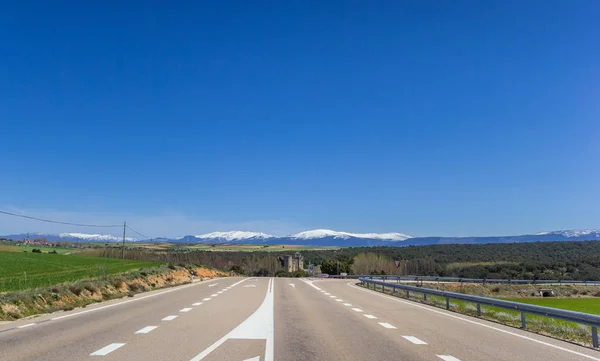 カスティーリャイレオン スペインで雪を頂いた山脈につながる高速道路 — ストック写真